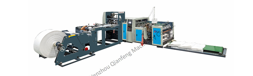 Wide shot of an industrial cutting sewing machine processing white PP woven fabric on a production line