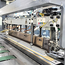 The operator is adjusting the bag cutting and sewing machine
