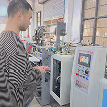 The operator is adjusting the bag cutting and sewing machine